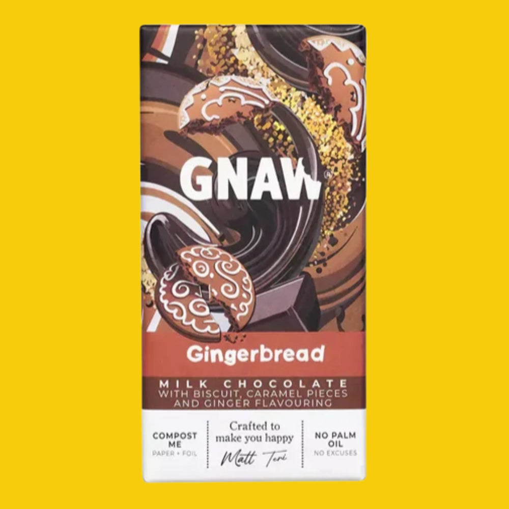 A rectangular box of GNAW Gingerbread Milk Chocolate compostable paper + foil packaging, shown centered on a solid bright yellow background. The box features a chocolate-dipped gingerbread cookie illustration and text including 'GNAW', 'Gingerbread', and 'MILK CHOCOLATE WITH BISCUIT CARAMEL PIECES AND GINGER FLAVOURING'.
