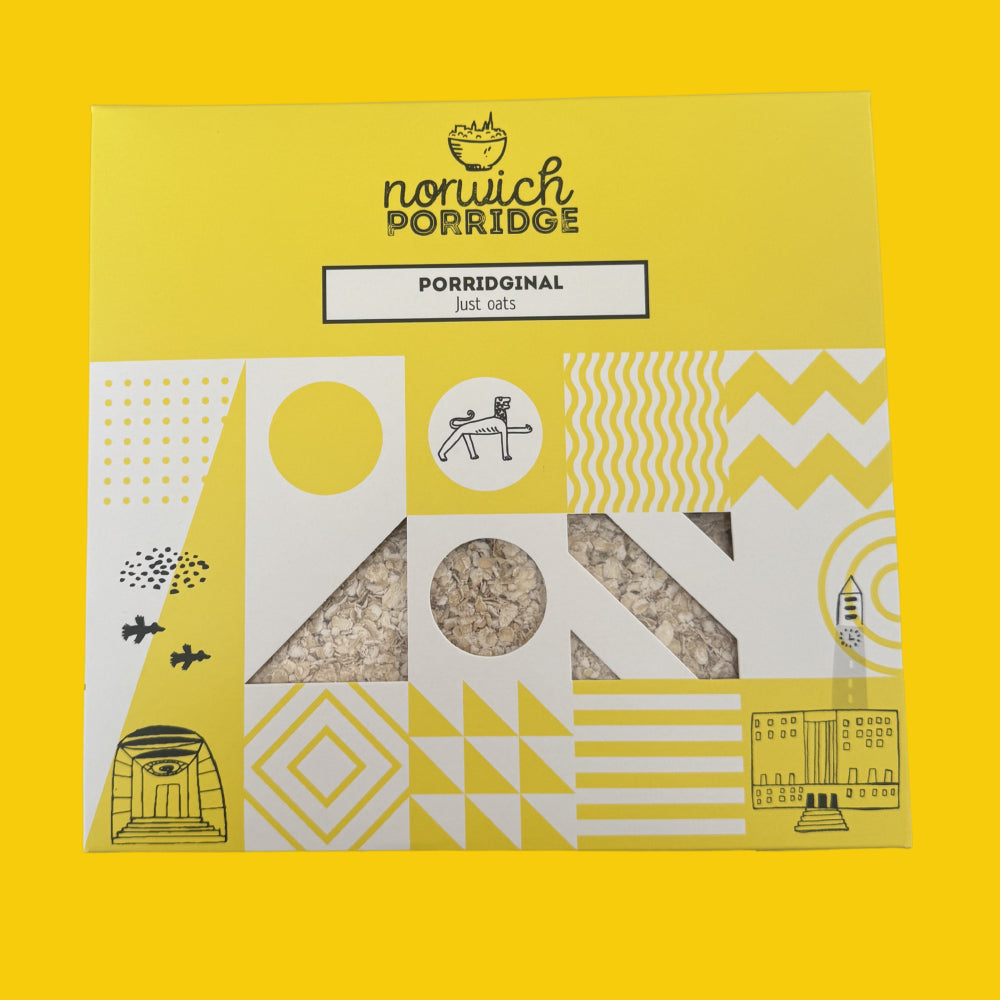 A package of Norwich Porridge Porridginal Just Cuts on a solid yellow background. The packaging is primarily yellow and white with black line art illustrations and two triangular windows showing the oatmeal-based porridge inside.